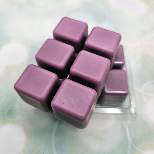 A set of wax melts in a clamshell on light green background with white circles.  The pictured scent is Dance, Destined Weaveress: Aglaea.