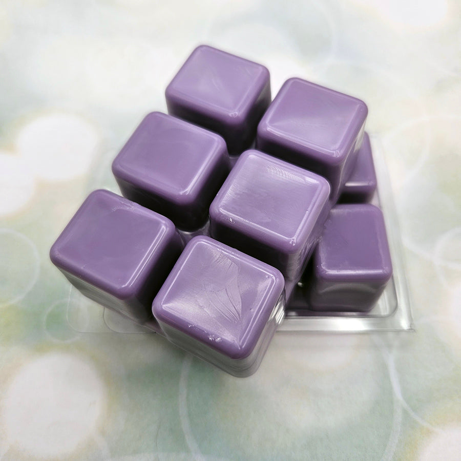 A set of wax melts out of a clamshell on light green background with white circles.  The pictured scent is Yours Truly, Kitty Phantom Thief!: Cipher.
