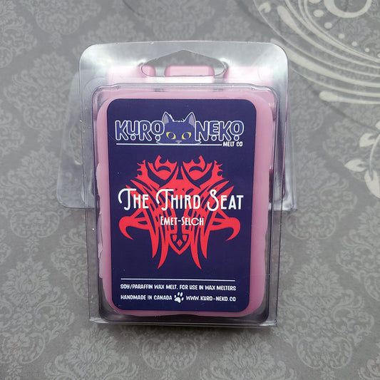 A set of wax melts in a clamshell on a dark grey patterned background. The pictured scent is The Third Seat: Emet-Selch.