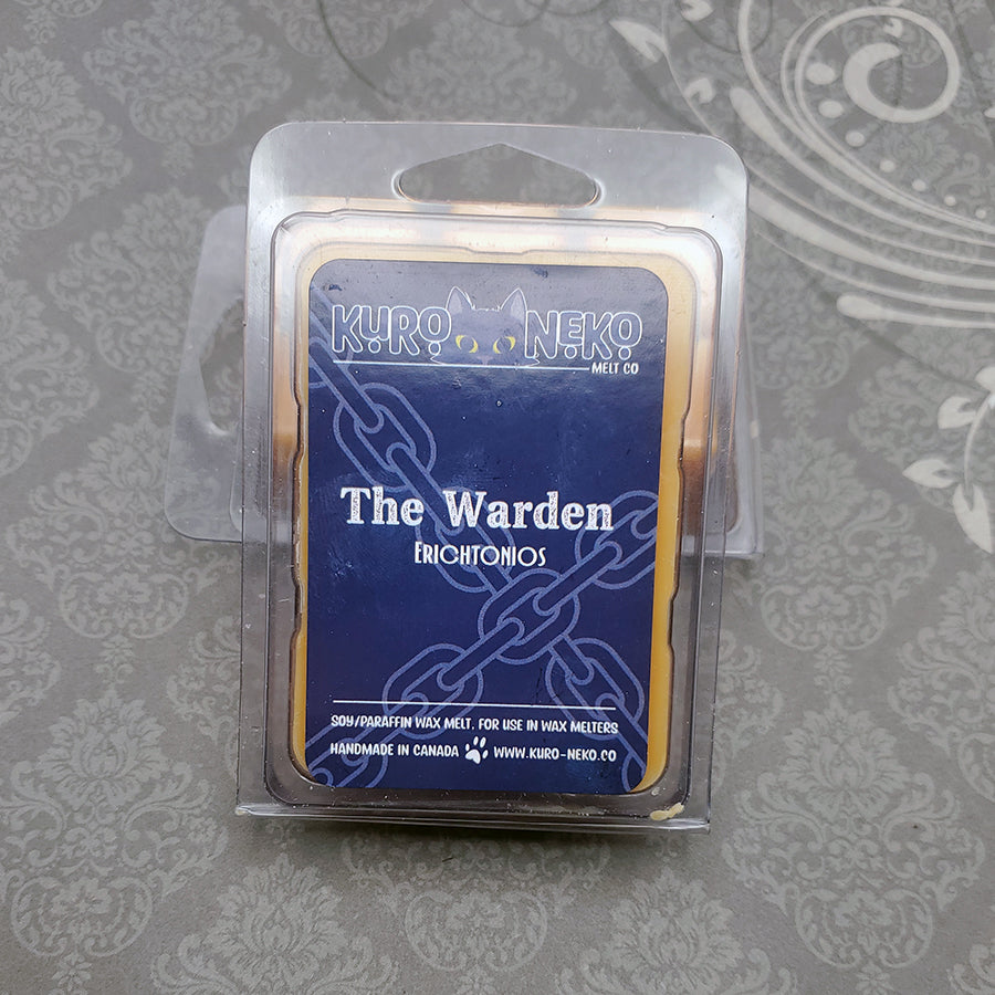 A set of wax melts in a clamshell on a dark grey patterned background. The pictured scent is The Warder: Erichtonios.