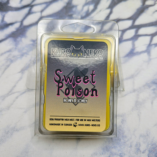 A set of wax melts in a clamshell on a dark blue and white tie dye background. The pictured scent is Claws in Sweet Poison: Honey B. Lovely.