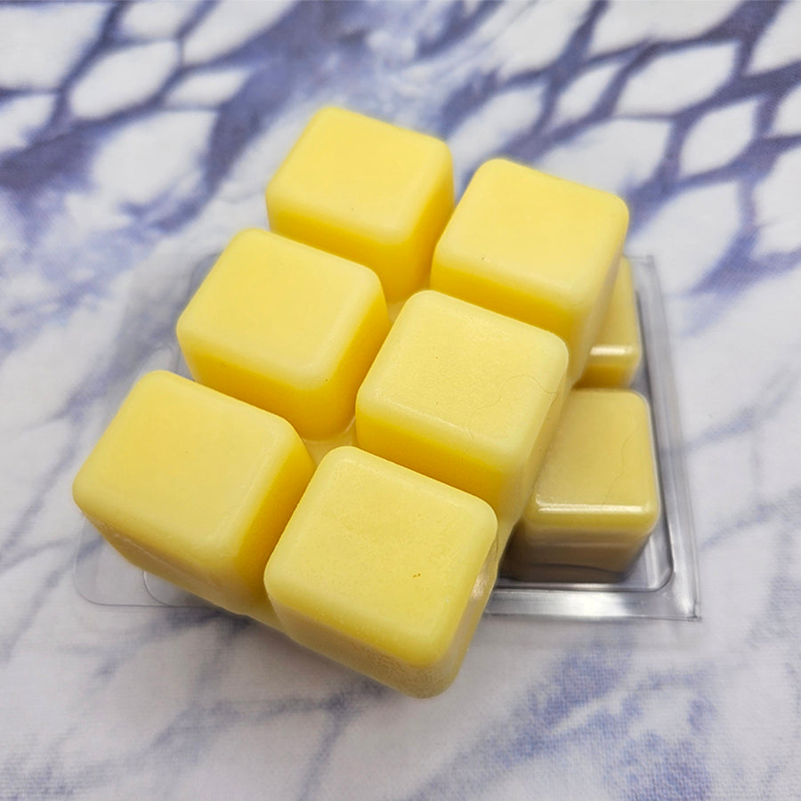 A set of wax melts in a clamshell on a dark blue and white tie dye background. The pictured scent is Discernment: Krile Baldesion.