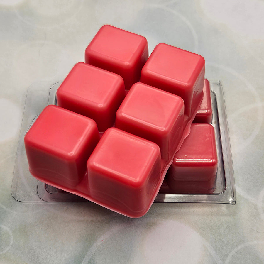 A set of wax melts out of a clamshell on a light green background with circles. The pictured scent is Dripping Mistscape: Lingsha.