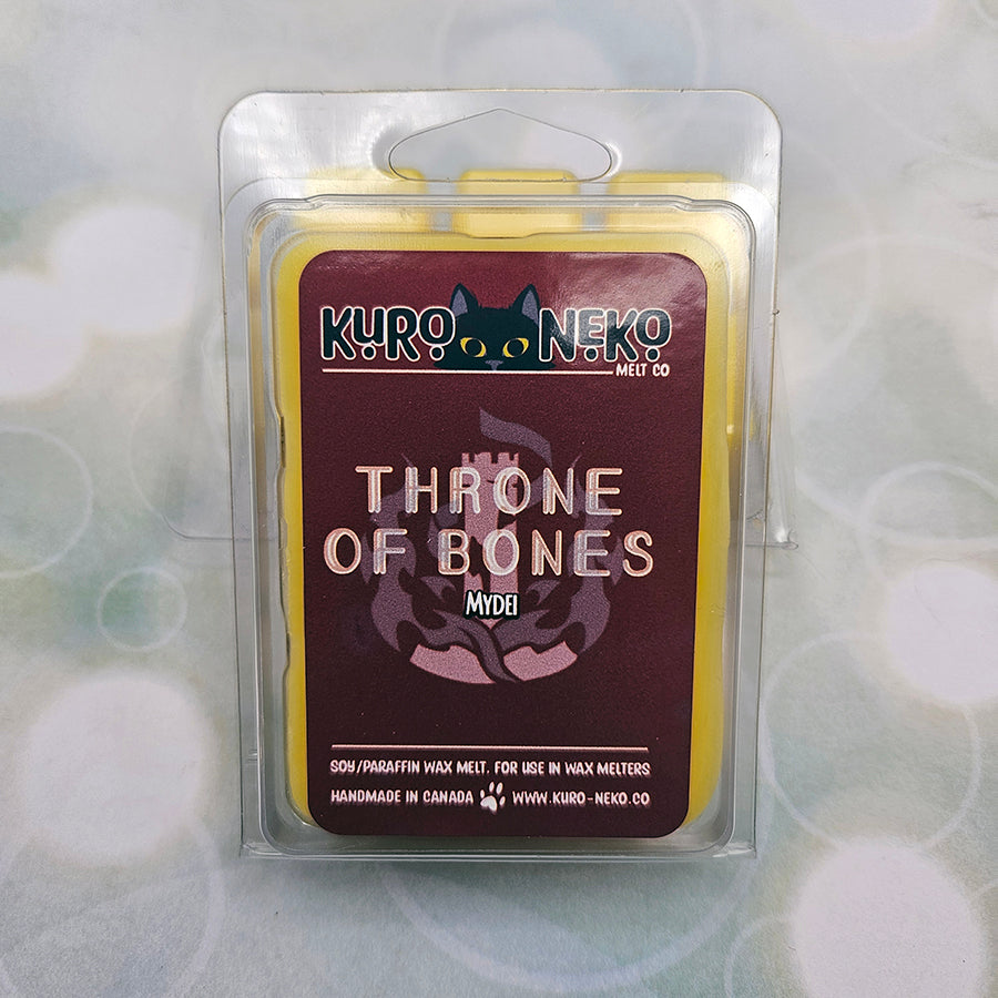 A set of wax melts in a clamshell on light green background with white circles. The pictured scent is Throne of Bones: Mydei.