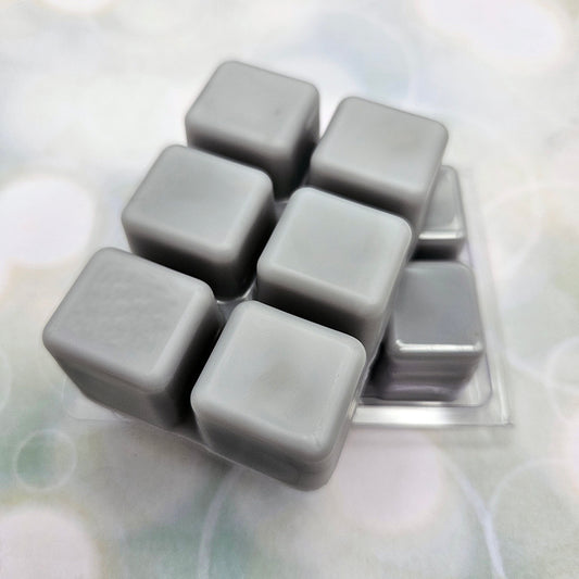 A set of wax melts in a clamshell on light green background with white circles.  The pictured scent is He Who Bears the World Must Burn: Phainon.