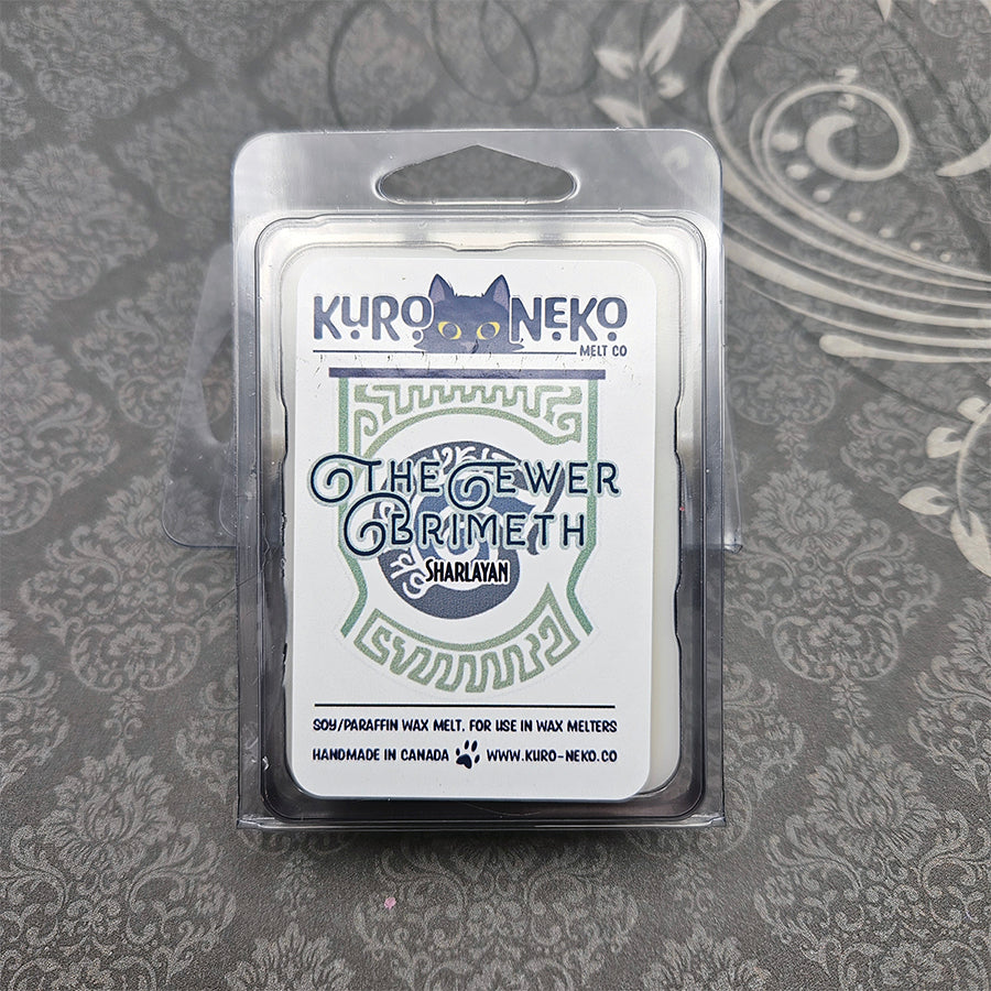 A set of wax melts in a clamshell on a dark grey patterned background. The pictured scent is The Ewer Brimeth: Sharlayan.