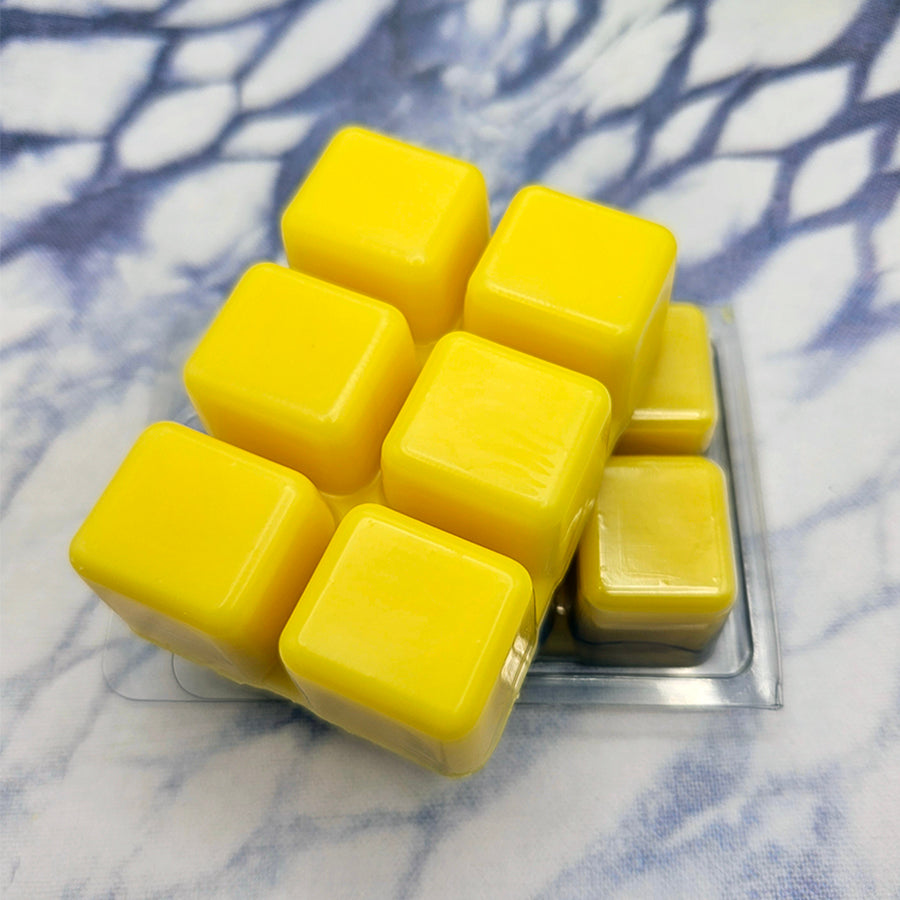 A set of wax melts in a clamshell on a dark blue and white tie dye background. The pictured scent is Queen Eternal: Sphene.